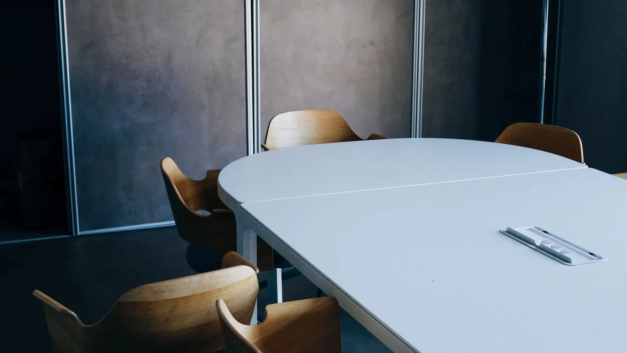 Sala de reuniones de una asesoría con una mesa despejada y sillas preparadas para atender a un cliente